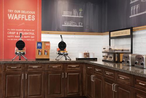 a kitchen with wooden cabinets and a counter top at Hampton Inn and Suites by Hilton Vero Beach-Downtown in Vero Beach