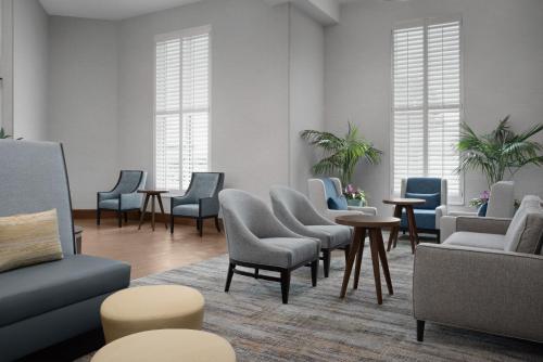 a waiting room with chairs and tables and windows at Hampton Inn and Suites by Hilton Vero Beach-Downtown in Vero Beach