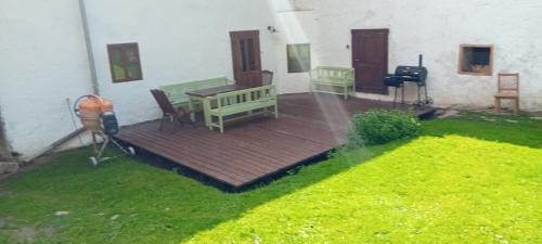 a porch with a wooden deck with a bench and grass at Chalupa Vagner, Pernek in Horní Planá