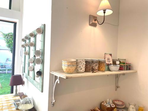 a shelf on a wall with bowls and pans at Casa Emma B&B in Saronno