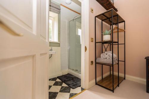 a bathroom with a shower and a glass door at Studio Sleeps 2 w HotTub-Garden-PetsOK-Parking in Cromer