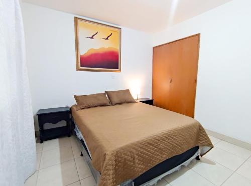 a bedroom with a bed and a picture on the wall at Hostal Casa Coliving Medellin in Medellín
