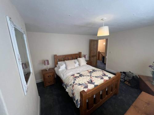 una camera con un grande letto e un comodino di Blyton 2-Bed Cottage Parking 30m to Lincoln a Blyton