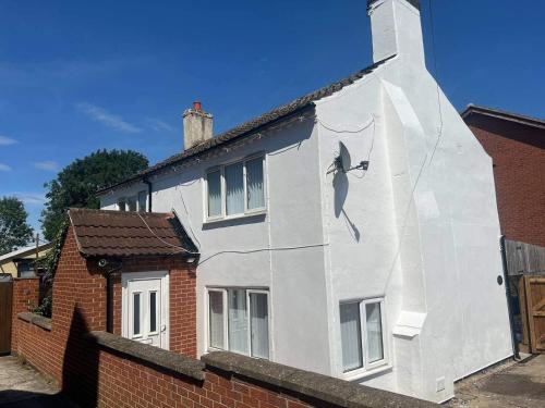 a white house with a painting on the side of it at Blyton 2-Bed Cottage Parking 30m to Lincoln in Blyton