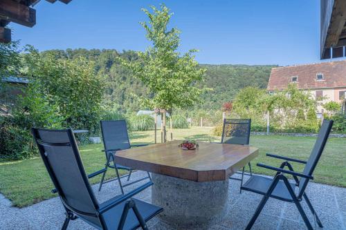 a table and chairs sitting around a stone table at Apartments in Stari trg ob Kolpi - Süd-Ost Slowenien 42908 in Stari Trg ob Kolpi
