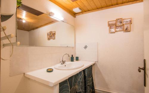 a bathroom with a sink and a mirror at Cozy Dourbie terrasse fibre tv parking in Millau