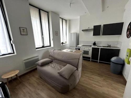 a living room with a couch and a kitchen at Le Grand Place in Arras