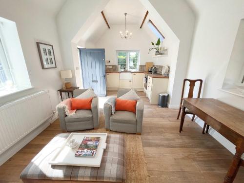 ein Wohnzimmer mit Tisch und Stühlen und eine Küche in der Unterkunft The Dairy cottage with garden and parking in Olveston