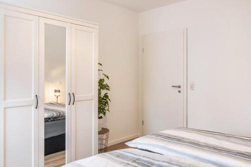 a white bedroom with a bed and a closet at Ferienwohnung Werratal in Barchfeld