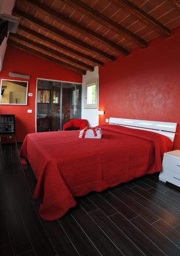 a red bedroom with a large bed with red walls at Bed & Breakfast Viziottavo in Castiglion Fiorentino