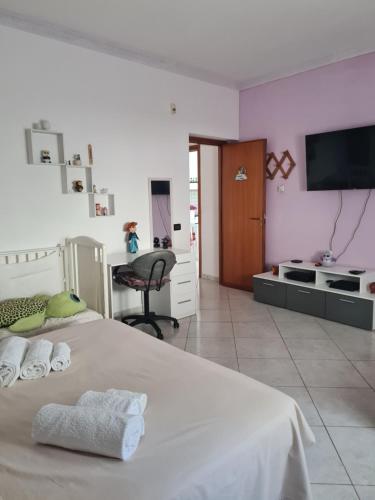 a bedroom with a bed and a desk and a television at Casa Nadiia in Cinisi