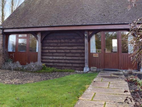un garage in legno con porta e prato di Byre Cottage - Meadowbrook Farm a Thame