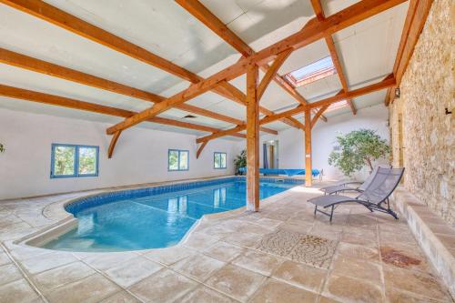 une piscine intérieure dans une maison avec poutres en bois dans l'établissement Cabane Amicie, à Monsac
