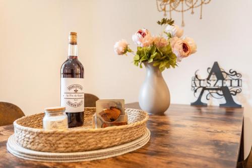 a bottle of wine and a vase with flowers on a table at Gästewohnung Auszeit in Regis-Breitingen
