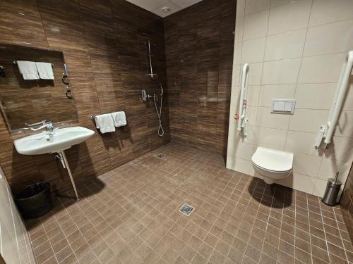 a bathroom with a sink and a shower and a toilet at City Yard Inn Hotel in Tallinn