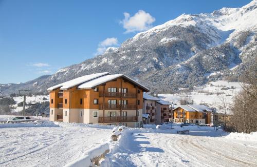 a large building in the snow with a mountain at Balcons B 037 - PARC NAT VANOISE appart 6 pers in Val Cenis