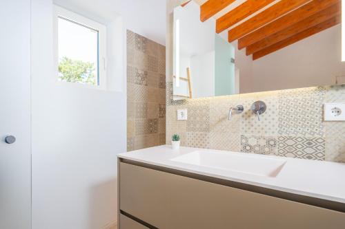 a bathroom with a white sink and a window at El Paraiso (Porto Cristo) in Porto Cristo