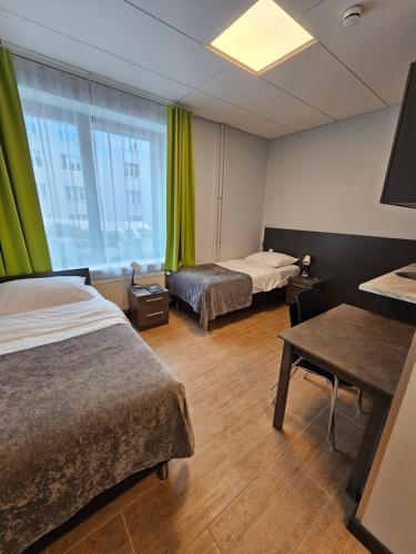 a hotel room with two beds and a window at City Yard Inn Hotel in Tallinn