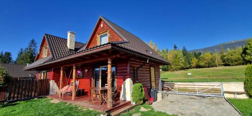 a small red house with a black roof at Babiogórskie Domki in Lipnica Wielka