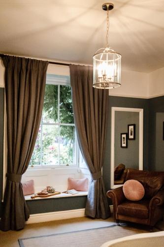 a window seat in a living room with a chandelier at Pendle View Apartment in Settle