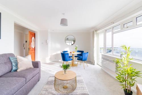 a living room with a couch and a table and chairs at WOW! SeaView Beach Apartment Sleeps 6-Free Parking in Bournemouth