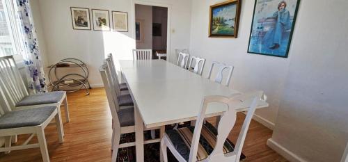 a white dining room with a white table and chairs at Large House with Two Apartments in Central Skarhamn in Skärhamn