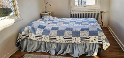 a bed with a blue and white blanket in a room at Large House with Two Apartments in Central Skarhamn in Skärhamn
