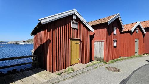 a red building with a yellow door next to the water at Spacious holiday home near Halleviksstrand, perfect for families in Ellös