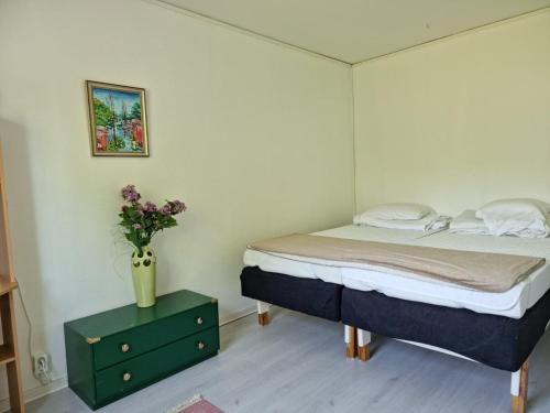 a bedroom with a bed and a vase of flowers on a table at Spacious holiday home near Halleviksstrand, perfect for families in Ellös