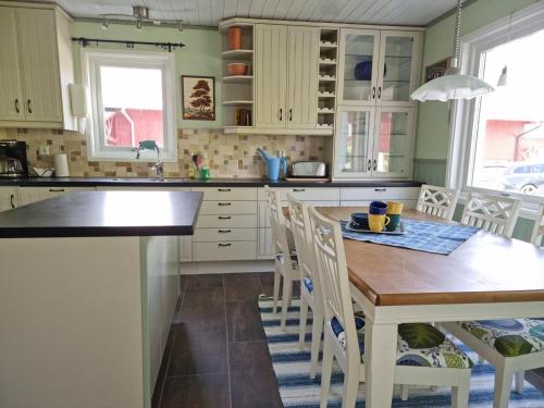 a kitchen with white cabinets and a wooden table at Spacious holiday home near Halleviksstrand, perfect for families in Ellös