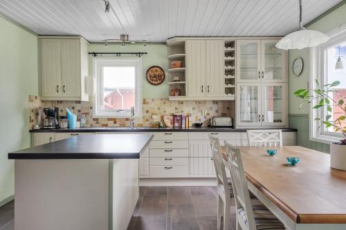 a kitchen with white cabinets and a wooden table at Spacious holiday home near Halleviksstrand, perfect for families in Ellös