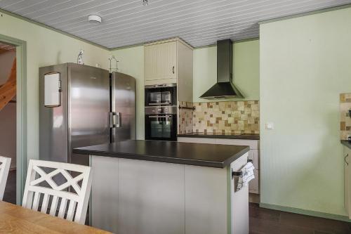 a kitchen with a stainless steel refrigerator and a table at Spacious holiday home near Halleviksstrand, perfect for families in Ellös