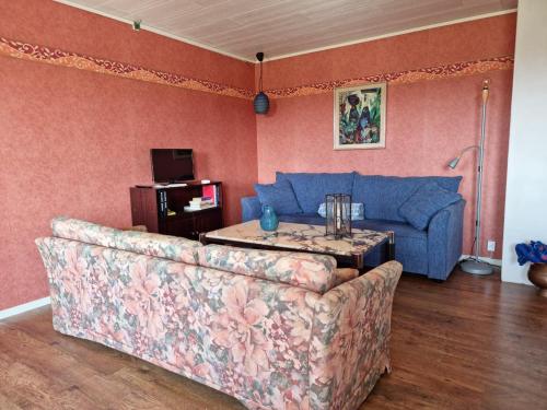 a living room with a blue couch and a table at Spacious holiday home near Halleviksstrand, perfect for families in Ellös