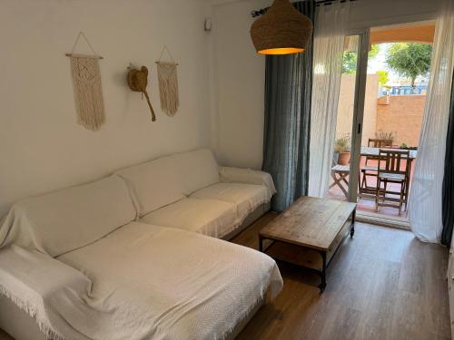 un soggiorno con un divano bianco e un tavolo di Beach Front House in Los Lances a Tarifa