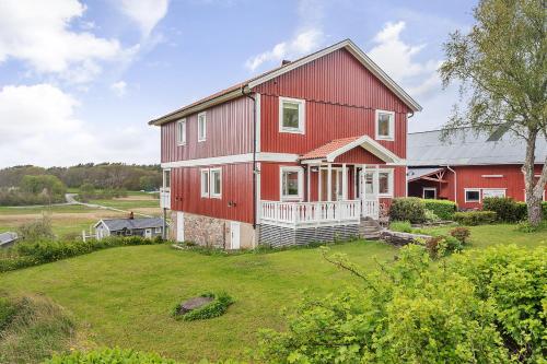 a large red house with a large yard at Spacious holiday home near Halleviksstrand, perfect for families in Ellös