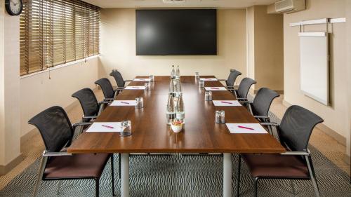 a conference room with a large wooden table and chairs at Crowne Plaza Manchester Airport by IHG in Hale