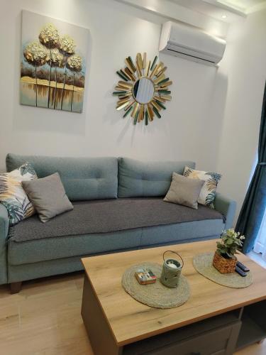 a living room with a blue couch and a table at Apartman Amber Vrnjačka Banja in Vrnjci