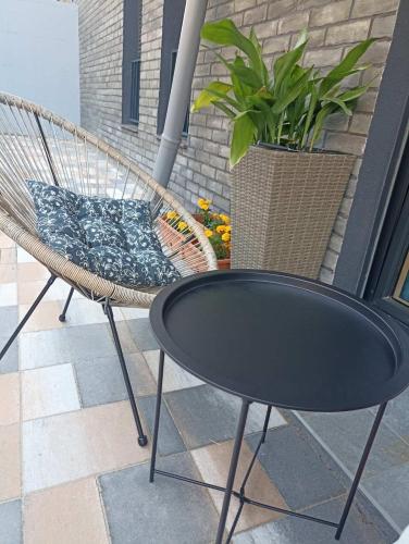 a hammock chair and a table on a patio at Apartman Amber Vrnjačka Banja in Vrnjci