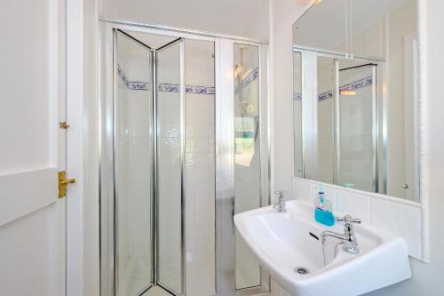 a white bathroom with a sink and a shower at Finest Retreats - Corrennie School Cottage in Inverurie