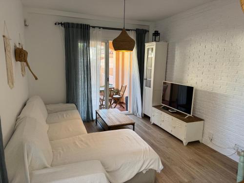 un soggiorno con un divano bianco e una TV di Beach Front House in Los Lances a Tarifa