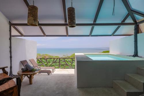 a house with a pool and a view of the ocean at Akua Suites Ocean View in Tarcoles