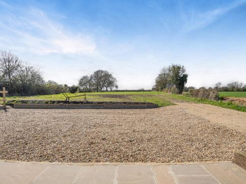 a dirt road with a bench in a field at Alberts Dairy in Diss