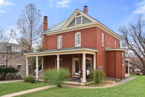 a large red brick house with a porch at Historic Queen Anne Family Home w Modern Comforts in Harpers Ferry
