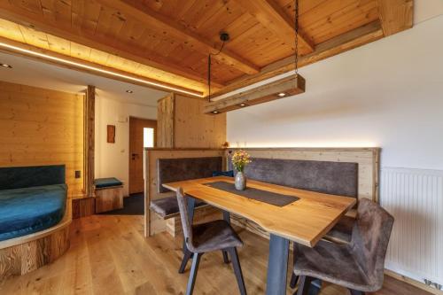 a dining room with a wooden table and chairs at Mühlanderhof Apt Piz Lad in Resia