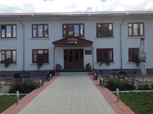 a large white building with a patio in front of it at Adina in Rîşcani
