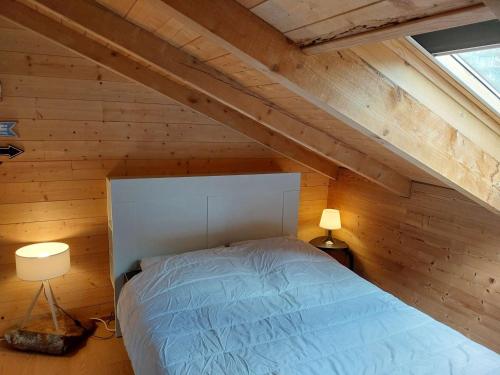 - une chambre avec un lit dans un grenier en bois dans l'établissement Charmant 2 pièces pour 5 pers, au pied des pistes, 24m², Vieil Alpe, Alpe d'Huez - FR-1-405-217, à Huez