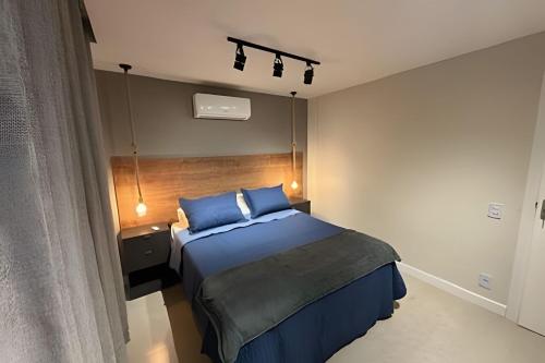 阿拉亚尔-杜卡布Todo reformado pertinho da praia的卧室里有一张带蓝色枕头的床
