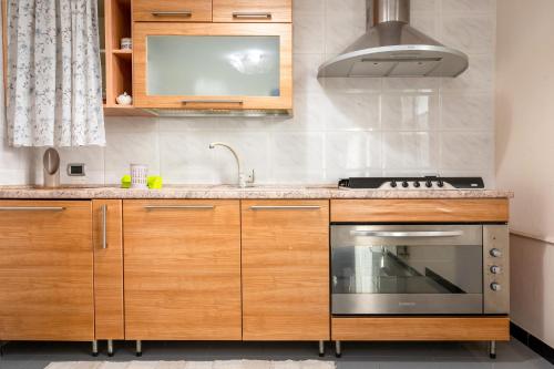 a kitchen with wooden cabinets and a stove at A casa di Pietro Sei in Leporano