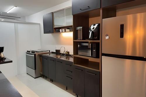 阿拉亚尔-杜卡布Todo reformado pertinho da praia的配有不锈钢冰箱和橱柜的厨房