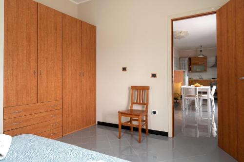 a bedroom with wooden cabinets and a chair and a table at A casa di Pietro Sei in Leporano